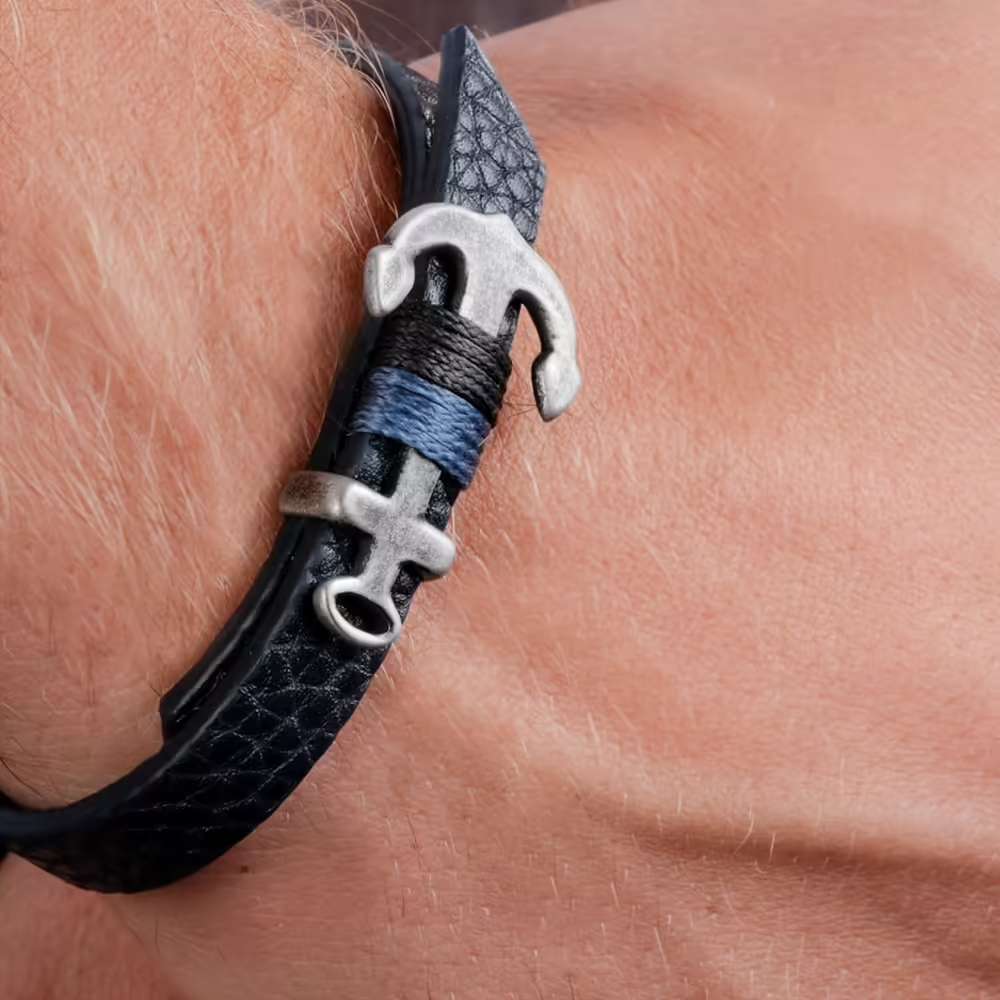 Bracciale in pelle blu con chiusura a forma di ancora e dettaglio in corda: uno stile deciso che richiama il mondo marinaro.